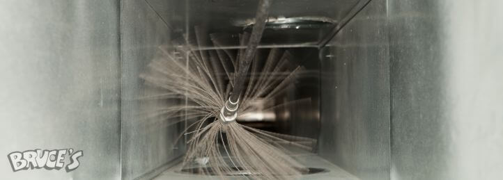 Rotary brush cleaning debris inside a residential air duct during professional duct cleaning service.