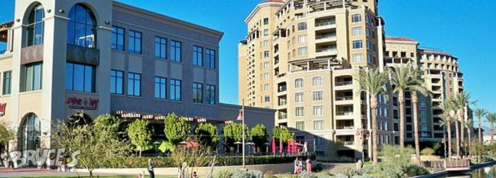 Upscale mixed-use development with retail storefronts, outdoor seating, and high-rise residential towers.